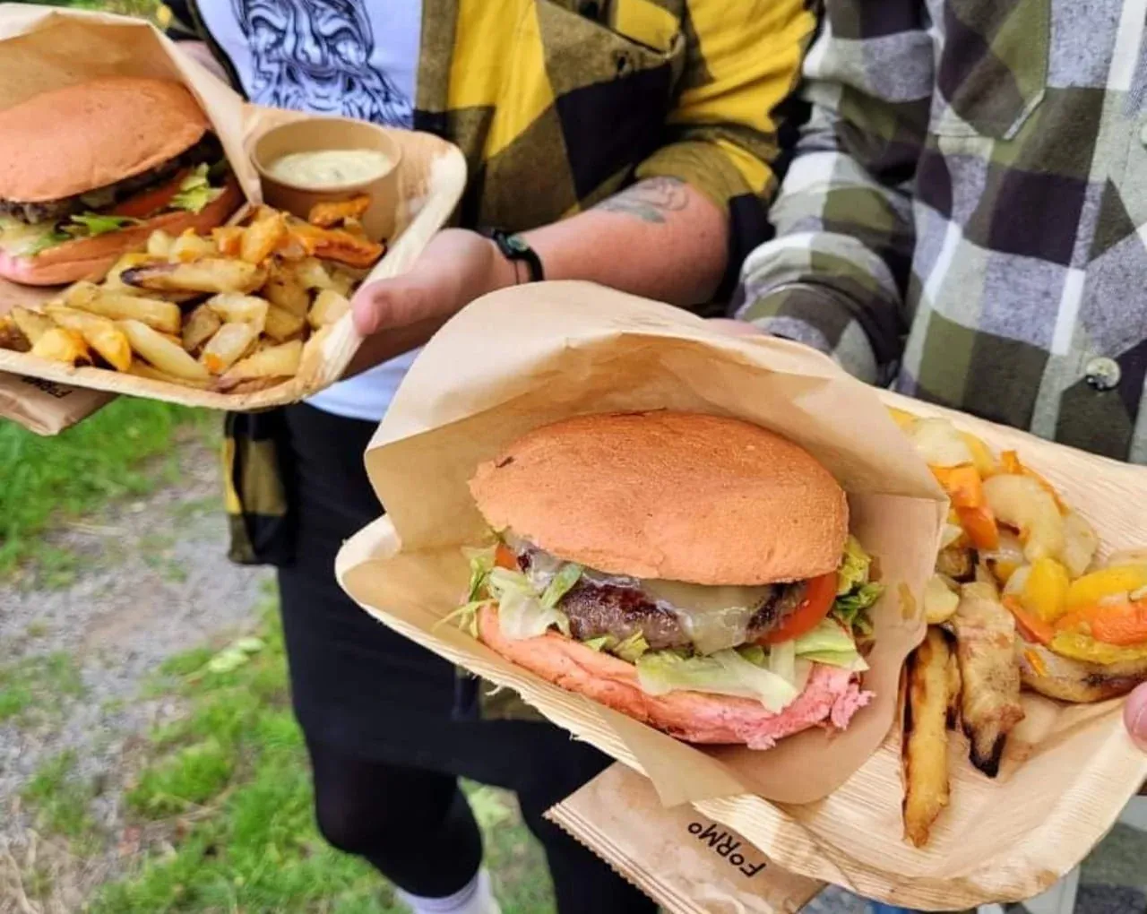 Två nygjorda hamburgare med pommes serverade i papperstråg